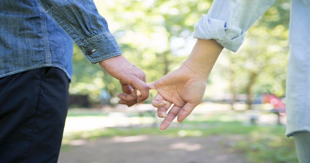 Pareja cogida de la mano, representación de las señales de dependencia emocional en una relación sentimental.