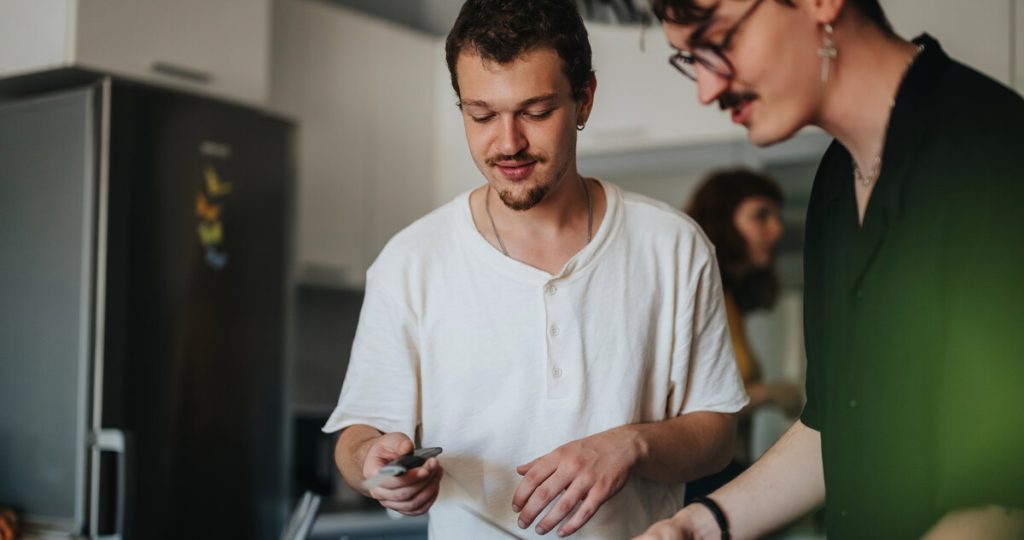 Dos jóvenes conviviendo y cocinando juntos en la cocina de un piso terapéutico